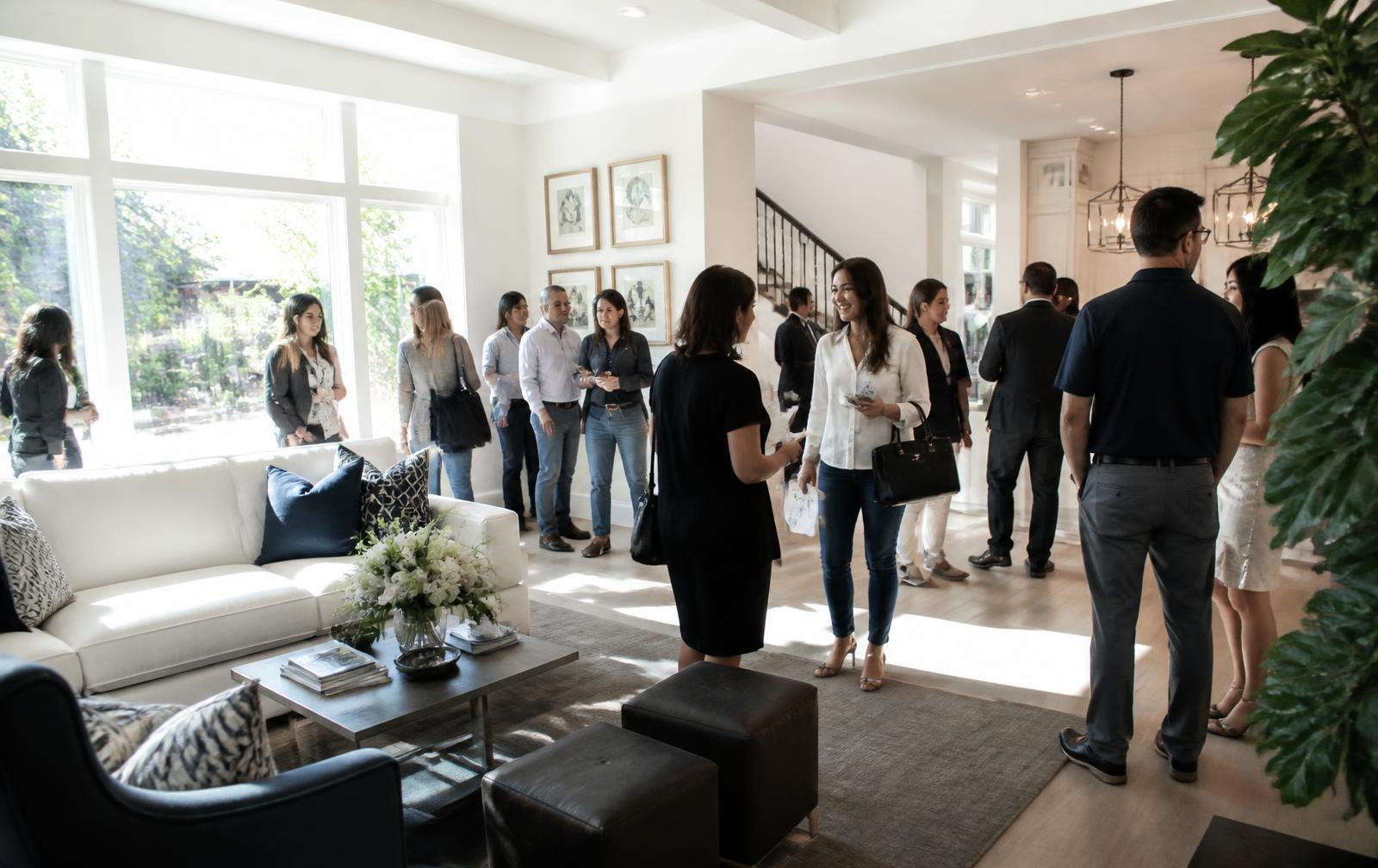 Agent talking with a couple in a packed open house living room